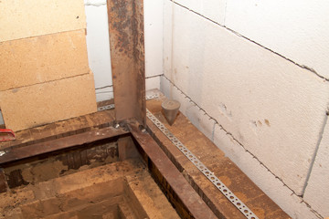 close up view of sauna stove that is being built from fire resistant material in undeveloped interior laid out of foam blocks in country house under construction