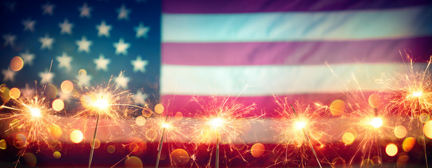 Usa Celebration With Sparklers And Blurred American Flag On Vintage Background
