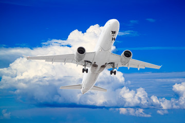 Fototapeta na wymiar white passenger plane take off with natural background of white clouds and blue sky
