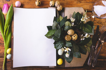 Easter menu on a wooden table decorated in eggs and fresh flowers.