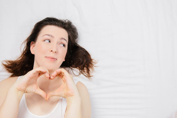 Naklejka premium Girl in bed on a white sheet with different emotions