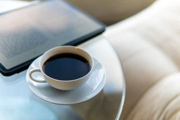 A cup of coffee and a tablet