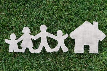 family of fourholding  hands over green grass background with a house
