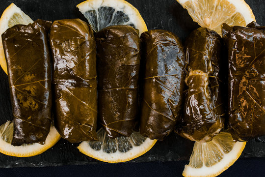 Dolma (stuffed grape leaves) top view on a black background. Mediterranean cuisine vegan dish
