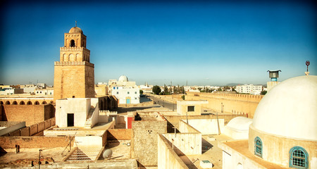 Traditional Arabic architecture in an urban landscape with dramatic sunlight. View of a city in...
