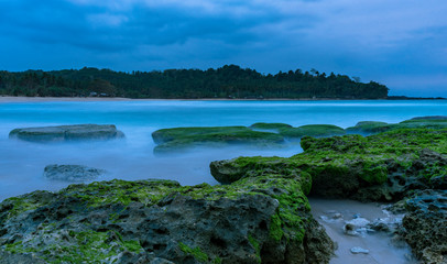 Fototapeta na wymiar Beautiful evening dark sunset long exposure beach scene with rocks and Indian ocean in Sawarna, Banten, Java, Indonesia