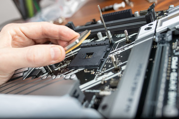 Fototapeta na wymiar Computer technician installing CPU into motherboard. Close up.
