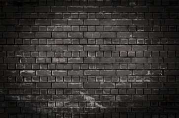 Texture or background of a dark brick wall with scratches and scuffs at night