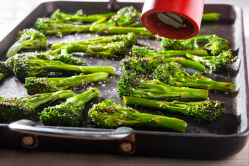 Broccoli roasted on an oven dish and a red pepper mill