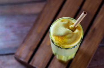 Golden milk, turmeric latte on wooden background. Natural detox beverage with spices.