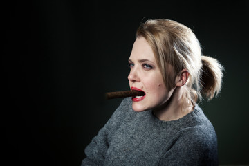 Obraz premium Woman with a cigar. The beautiful blonde. Black background