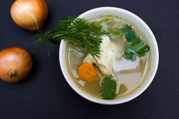Traditional fish soup on blak, dark background. Fish soup is a food made by combining fish or...