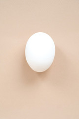 Raw fresh chiken egg isolated on cream background