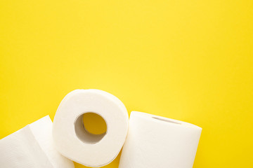top view of white toilet paper rolls on yellow background