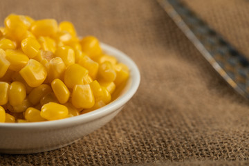 Corn seeds in a white saucer on the table