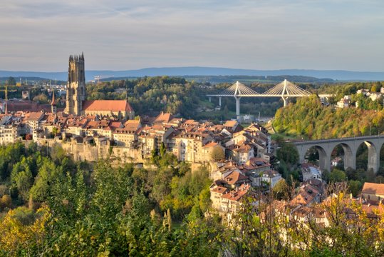 Panoramic view of cathedral of St. Nicholas, new Poya and old Zaehringen bridge by night, Fribourg, Switzerland, HDR