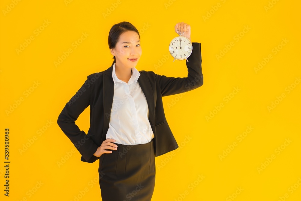 Wall mural Portrait beautiful young asian woman show clock or alarm