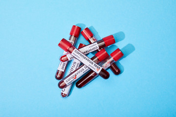 top view of test tubes with blood samples and coronavirus test lettering on blue