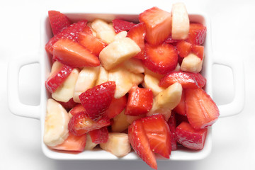 STRAWBERRY AND BANANA FRUIT SALAD ON WHITE BACKGROUND
