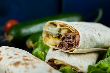Meat shaurma rolls in a platter with mixed vegetables