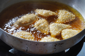 Deep firied Malaysia traditional chicken curry puff in the hot boiling oil.
