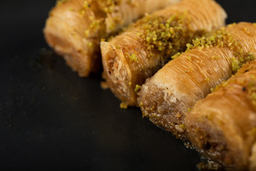 Turkish pakhlava served with minced pistacchio in a black platter