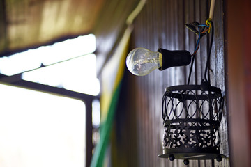 An interesting lamp hanging on the outside wall of the house. Photo of a light bulb.