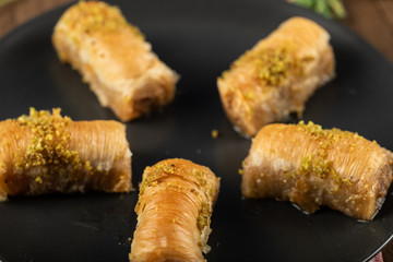 Turkish delight pakhlava served with minced pistacchio, isolated on black