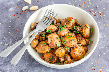 Sauteed Mushrooms in Garlic Butter in a Bowl with Forks Garnished with Herbs and Chili Flakes Horizontal Photo