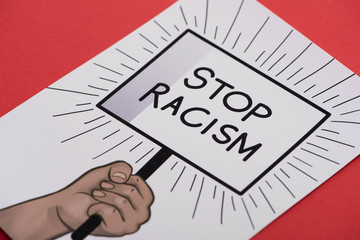 picture with drawn hand and stop racism placard on red background