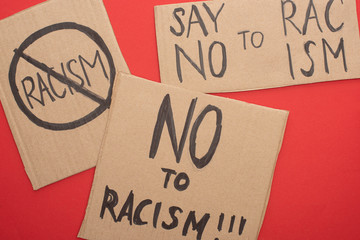 top view of carton placards with no to racism lettering on red background
