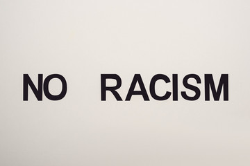 top view of black no racism lettering isolated on white