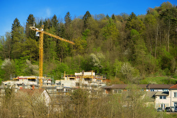 Tall yellow crane builds a house in the forest