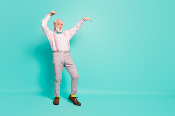 Full body photo of crazy old retired man dance vintage concert event raise hands wear pink shirt grey trousers shoes isolated over turquoise color background
