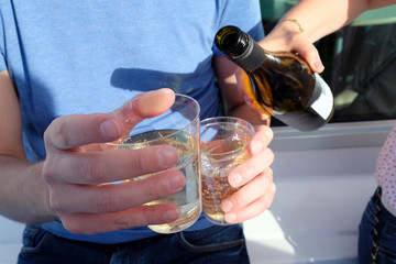 Pouring white wine into cups during a picnic