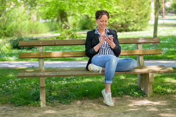 Fototapeta premium Smiling trendy Hispanic woman using a mobile