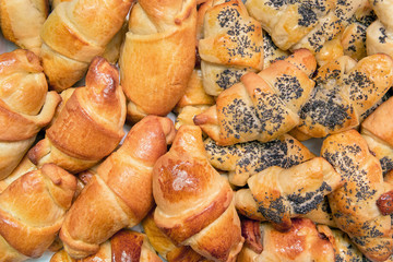 Fresh homemade baking background, burgers with poppy seeds, croissant, culinary composition