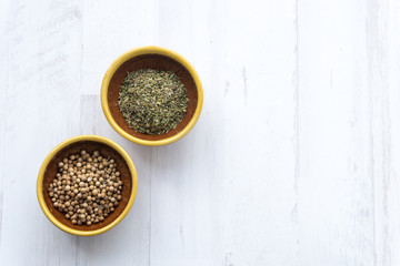 Two small bowls with coriander and spice mix for cooking