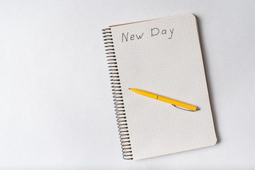 Inscription NEW DAY in notepad. Beginning of the day. Handwritten inscription in notebook.