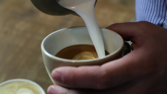 Close-up of a vintage barista making an artistic composition with fresh milk to make a cappuccino using an Italian espresso.
Italian concept, passion for work, breakfast and love for coffee and art.