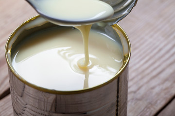 open canned condensed sweet milk in an iron can