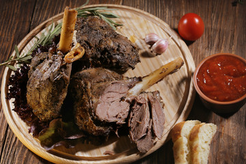 Roasted turkey meat which lies on a board with ketchup,red pepper and bread.