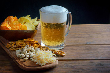 a glass of light beer with snacks