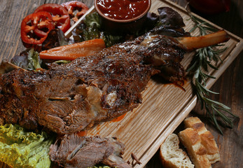 Roasted turkey meat which lies on a board with ketchup,red pepper and bread.