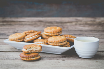 vintage soft tone of cookies bread and a Teacup on wooden table. Menu set for afternoon snack.
