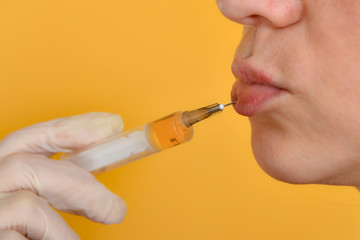 Lip injections with a syringe for lip augmentation in a beauty salon.