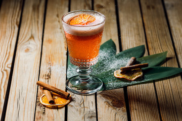 orange rum cocktail and spritz aperol with airy foam and orange chips on a wooden background with lines and cinnamon sticks. bar menu concept