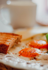 breakfast with fried eggs, fresh vegetables, cheese,bread and coffee