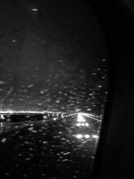 Illuminated Airport Runway Seen From Wet Window Glass