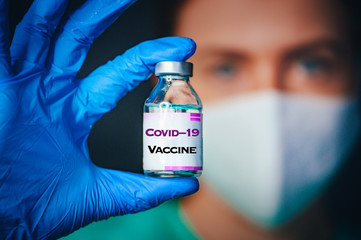 Coronavirus Covid-19 Protection and Vaccine. Female doctor, protect mask, portrait, Medicine bottle for injection medical glass vials for vaccination. Tittle 